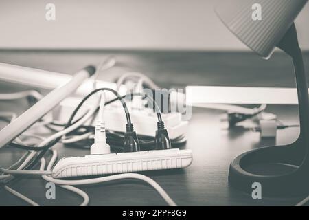 Viele Stecker, die mit einzelnen Schaltern an die Steckerleiste angeschlossen sind. Stockfoto