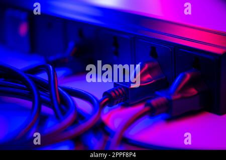 Viele Stecker sind an die schwarze Steckerleiste angeschlossen. Stockfoto