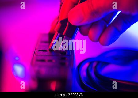 Nahaufnahme einer hand, die einen Stecker in die Steckdosenleiste steckt. Stockfoto