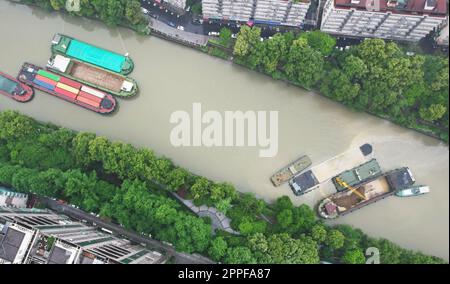 HANGZHOU, CHINA - 24. APRIL 2023 - Luftfoto zeigt ein Rettungsschiff mit gelbem Sand von einem versunkenen Frachtschiff auf dem Canal Grande Peking-Hangzhou Stockfoto