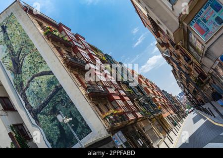 Bilbao, Spanien - 10.06.2022: Enge Gassen mit farbenfrohen Balkonen und schrägem Blick Stockfoto