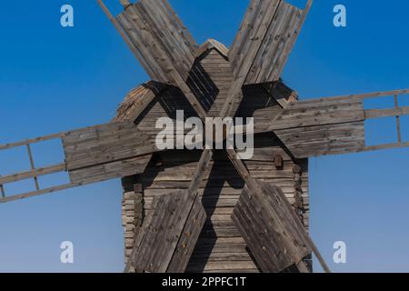 Nahaufnahme einer alten ukrainischen Holzwindmühle vor blauem Himmel Stockfoto