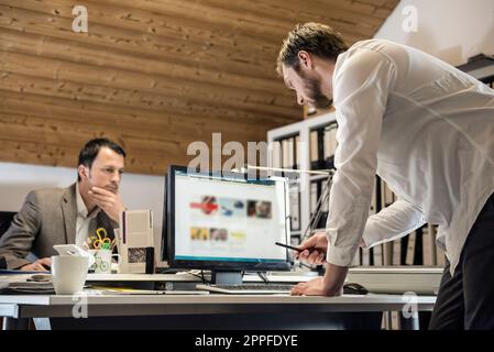 Zwei Geschäftsleute, die am Computer arbeiten, in einem Büro, Bayern, Deutschland Stockfoto