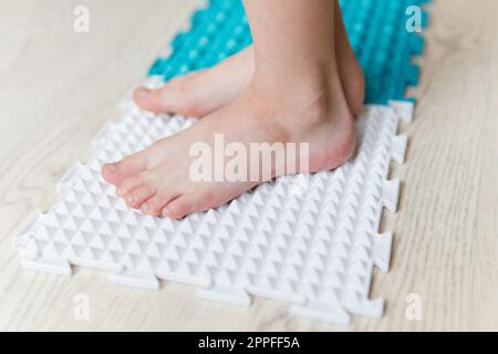 Kinderfüße auf einer orthopädischen Matte Stockfoto