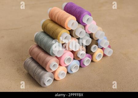 Satz farbiger Nähfäden auf grauem Tisch Stockfoto