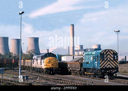 Eine Diesellokomotive der Klasse 37 Nummer 37227 und ein Diesel-Shunter der Klasse 08 Nummer 08904 sind in Didcot Yard Behind stationiert, wobei das Kraftwerk Didcot am 28. Oktober 1995 den Hintergrund dominiert. Stockfoto