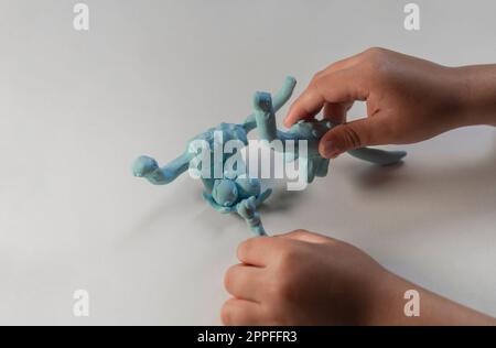 Kind, das mit plastischen Dinosaurierfiguren spielt. Stockfoto