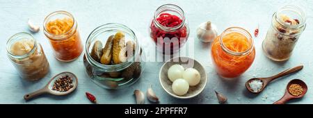 Panorama fermentierter Speisen. Gemüsekonserven. Sauerkraut, Gurken, Kimchi usw. in Glasgefäßen. Gesunde probiotische Diät Panorama-Banner Stockfoto