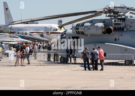 BERLIN - 23. JUNI 2022: Besucher der Ausstellung auf dem Flugplatz vor dem Hintergrund verschiedener Flugzeuge. Ausstellung ILA Berlin Air Show 2022 Stockfoto