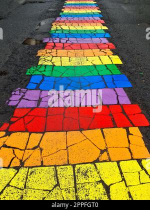 Seydisfjordur, Island - 23. Juni 2022: Die berühmte Regenbogenstraße in Seydisfjordur mit isländischen Gebäuden um bemalte Wände. Stockfoto