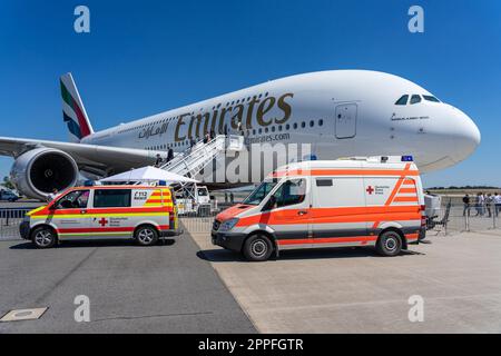 BERLIN, DEUTSCHLAND - 23. JUNI 2022: Zwei Krankenwagen vor dem größten Passagierflugzeug der Welt - Airbus A380-800. Emirates Airline. Ausstellung ILA Berlin Air Show 2022 Stockfoto