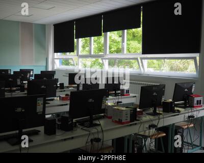 Sremska Mitrovica, Serbien, 15. Mai 2021 Computergruppe, die ordentlich in einem Computerlabor aufgestellt wurde. Computer, Monitore, Kabel im modernen Klassenzimmer der neuen Schule. Schreibtische für Schüler und Studenten Stockfoto