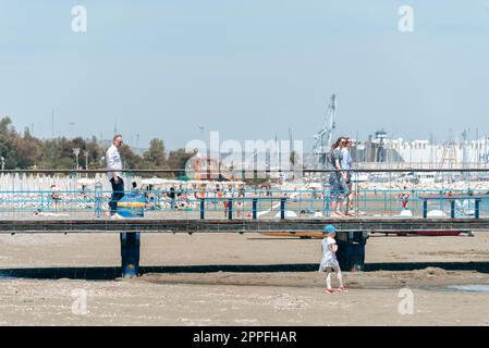 Larnaca, Zypern - 16. April 2022: Menschen, die am Strand von Finikoudes entlang spazieren Stockfoto