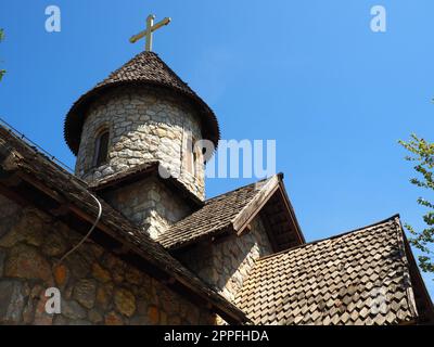 Stanisici, Bijelina, Bosnien und Herzegowina, 25. April 2021. Steinorthodoxe Kirche im Ethno-Park. Religiöser Tourismus. Ein Gebäude aus Steinen mit einem Kreuz auf der Kuppel. Blauer Himmel Stockfoto