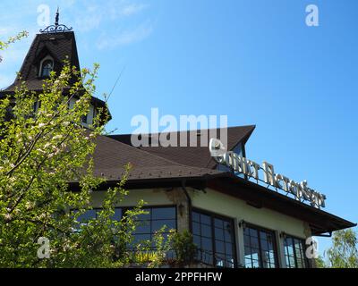 Stanisici, Bijelina, Bosnien und Herzegowina, 25. April 2021. Modernes, stilvolles Gebäude des St. Petersburg Restaurant, Dach und Wetterfahne. Blauer Himmel und Birke. Die Inschrift - St. Petersburg Stockfoto