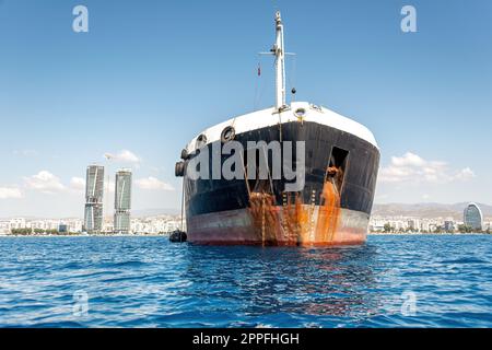 Ölprodukte-Tankschiff in der Akrotiri Bay mit Limassol-Skyline im Hintergrund. Zypern Stockfoto