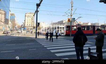 Belgrad, Serbien - 24. Januar 2020: Fußgängerüberquerung mit Menschen auf dem Slavia-Platz im Zentrum von Belgrad. Aktiver Verkehr, Fußgänger überqueren die Straße auf den weißen Zebrastreifen. Straßenmarkierung Stockfoto