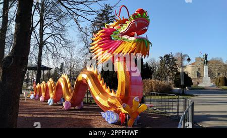 Chinesisches Neujahr. Leuchtender rot-orangefarbener Drache im Park. Traditionelle chinesische Weihnachtsdekoration. Der Mund des Drachen ist offen. Langer, lockiger Schwanz. Mondsolar-Kalender. Frühlingsfest Stockfoto