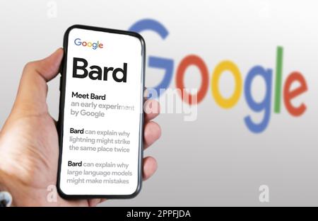 Eine Hand, die ein Telefon hält, während die Google Bard-Website auf dem Bildschirm angezeigt wird Stockfoto