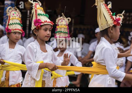 Junge balinesische Mädchen, die während der Kuningan-Zeremonie auf Bali tanzen Stockfoto