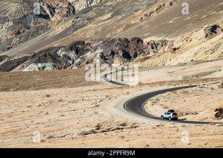 Death Valley gewundene Straße durch farbenfrohe Berge mit einigen Autos Stockfoto