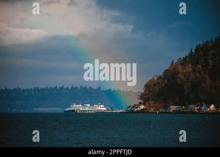 Ein farbenfroher Regenbogen über dem Puget Sound und der Fähre Stockfoto