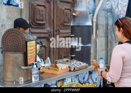 Straßenverkäufer von heißen Kastanien auf Holzkohle in Porto, Portugal Stockfoto