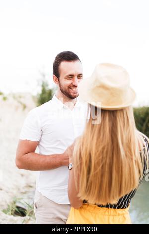 Der Mann lächelt, während er die Hände einer Frau hält Stockfoto