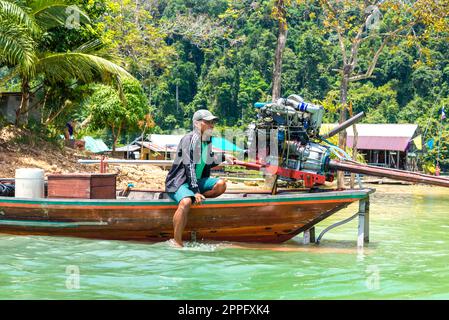 Ortskundiger Reiseleiter auf einem Langboot, der auf Touristen wartet, um Abenteuerausflüge am Pier der Ranger-Station zu Unternehmen Stockfoto