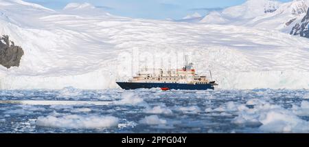 Expeditionsschiff vor der antarktischen Eisbergslandschaft in Cierva Cove auf der Westseite der antarktischen Halbinsel Stockfoto