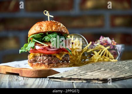 Burger mit Speck serviert mit Rotkohlsalat und pommes frites Stockfoto