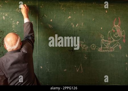 Lehrer an der Schule schreibt auf die Tafel, lustiges Bild. Stockfoto