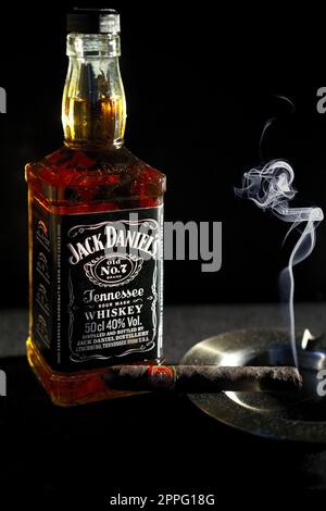 Minsk, Belarus - 25. Januar 2016: Flasche Jack Danielâ€™s in der Nähe des Aschenbechers mit Zigarrenraucher Stockfoto