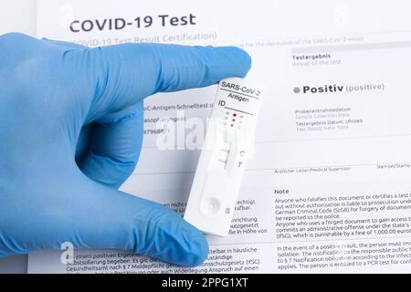 Positives Testergebnis durch Verwendung eines Schnelltestgeräts für COVID-19. Stockfoto