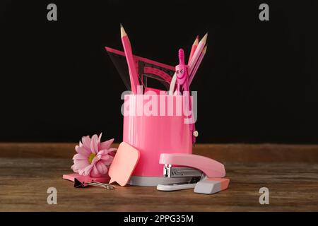 Schreibwaren und Blumen auf einem Holztisch in der Nähe der Tafel. Lehrertag Stockfoto