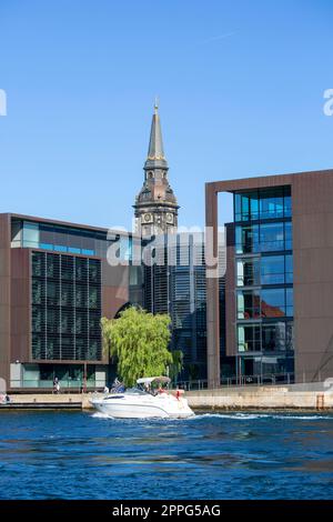 Kopenhagen, Dänemark - 22. Juni 2019: Modernes Gebäude des dänischen Steuerministeriums (Skatteministeriet Departementet) und Turm der christlichen Kirche Stockfoto