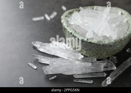 Menthol-Kristalle in der Schüssel auf grauem Hintergrund, Nahaufnahme Stockfoto