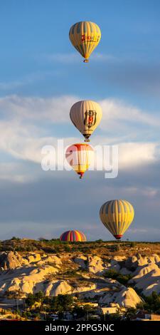 Eine Gruppe Heißluftballons fliegen bei Sonnenaufgang in die Nähe von Goreme. Stockfoto