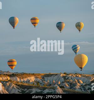 Heißluftballons fliegen über die Hügel Stockfoto