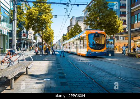 Mannheim, Deutschland - 10. Juni 2022: Bunte Straßenbahnen in der Mannheimer Innenstadt, Einkaufszentrum ohne Autos, Einkaufsstraße Planken Stockfoto