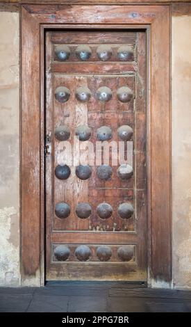 Grunge-Holztür an Grunge-Steinwand Stockfoto