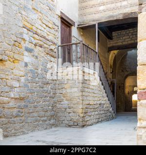 Alte verlassene Treppe mit Holzbalustrade und Holztür an Steinsteinpassage, Kairo, Ägypten Stockfoto