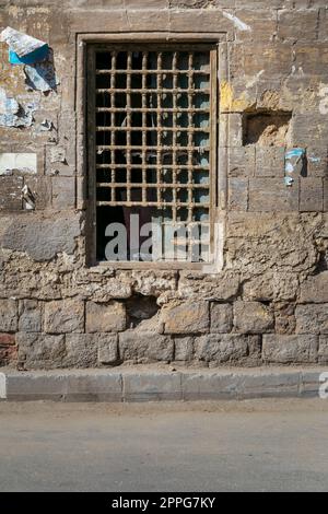 Alte verlassene Steinmauern mit einem geschlossenen Grunge zerbrochenes Holzfenster mit Holzgitter Stockfoto