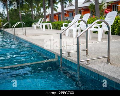 - Edelstahltreppe zum Pool. Handläufe am Pool hoch und runter. Stockfoto