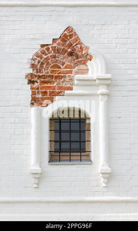 Das Figurenfenster In Der Alten Weißen Backsteinmauer Stockfoto