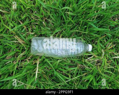 Flasche frisches Wasser auf grünem Gras, Draufsicht Stockfoto