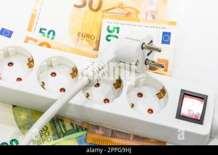 Steckdosenleiste und Euro-Banknoten. Konzept der steigenden Strompreise Stockfoto