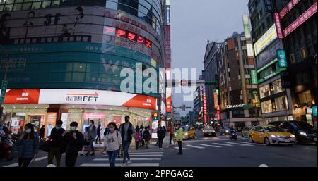 Taipei, Taiwan, 20. März 2022: Taipeh City Street mit Menschen, die die Straße am Abend überqueren Stockfoto