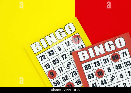 Gelbe und rote Bingo-Boards oder Spielkarten für Siegerchips. Klassische US- oder kanadische fünf bis fünf Bingo-Karten auf hellem Hintergrund Stockfoto