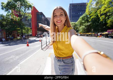 Reisen Sie in Sao Paulo, Brasilien. Ein wunderschönes lächelndes Mädchen macht Selbstporträts auf der Paulista Avenue, Sao Paulo, Brasilien. Stockfoto